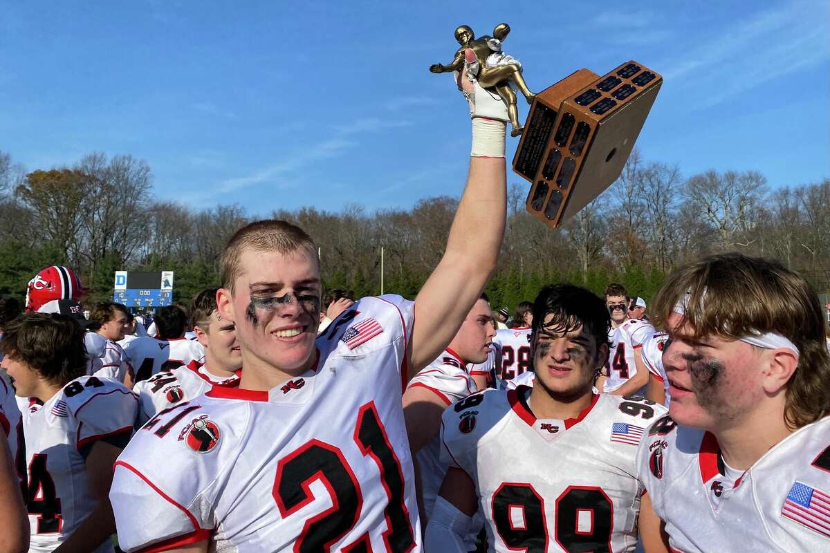 New Canaan's Walker Blair with the Coaches' Trophy after New Canaan beat Darien 13-10.