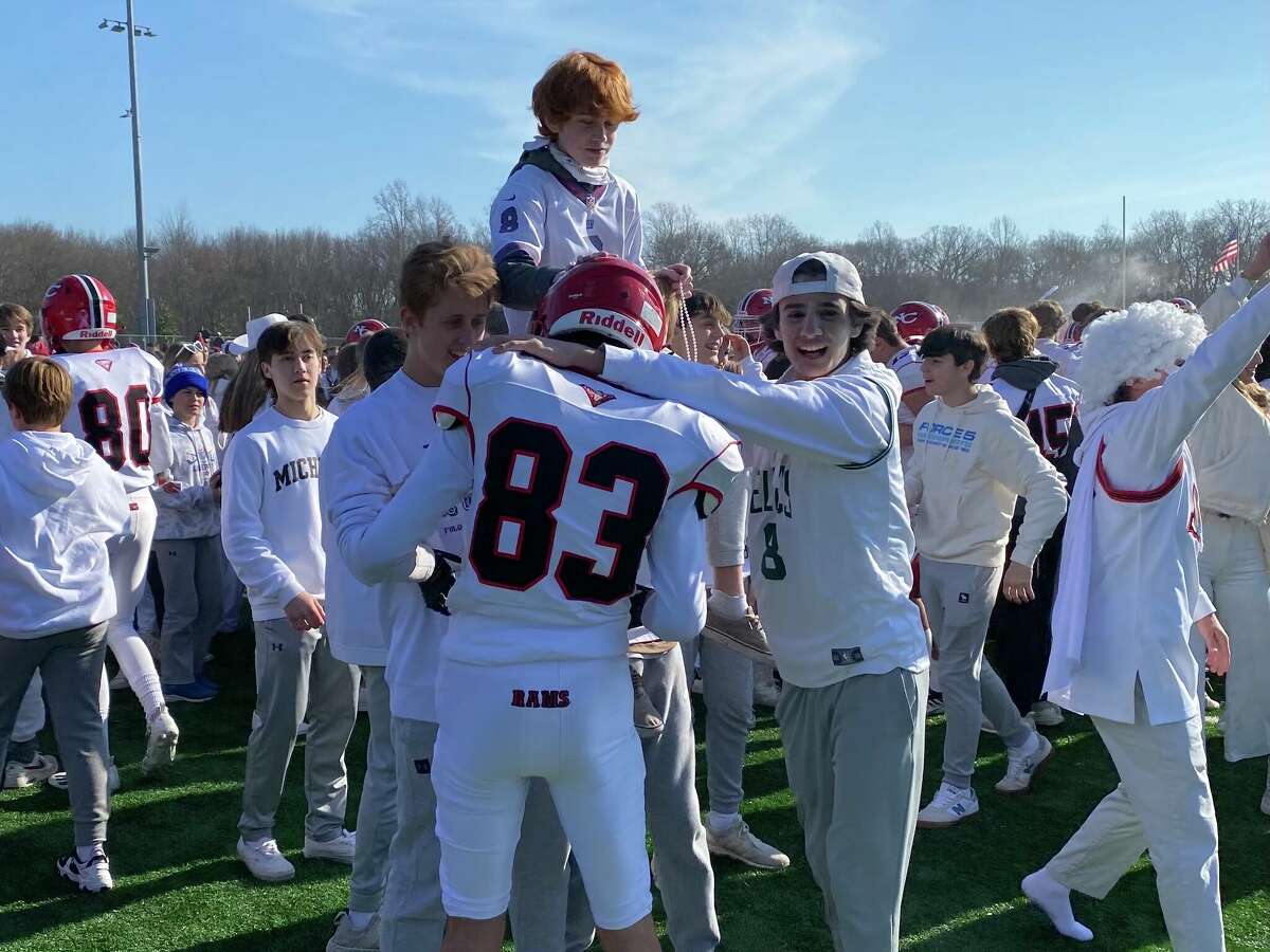 New Canaan celebrates with fans after winning the 2022 Turkey Bowl.