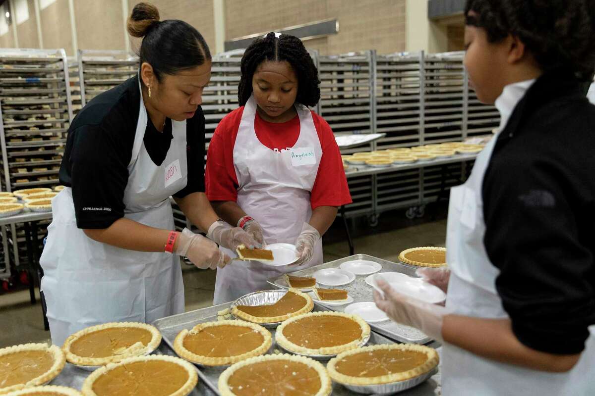 Leak Williams and her daughter, Angela Frierson, slice and plate pumpkin pies that will be served to an estimated 25,000 people at the annual Jimenez Thanksgiving dinner. The Thanksgiving feast is held at the Henry B. Gonzalez Convention Center and has been going since 1979. This is the first in person dinner since COVID.