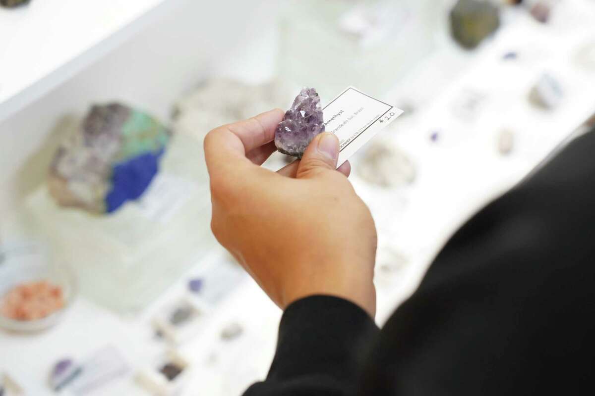 A customer holds a piece of Braziian amethyst, one of many Brazilian rocks available for sale, at the Katy Rock Shop on November 23, 2022 in Katy, Texas.