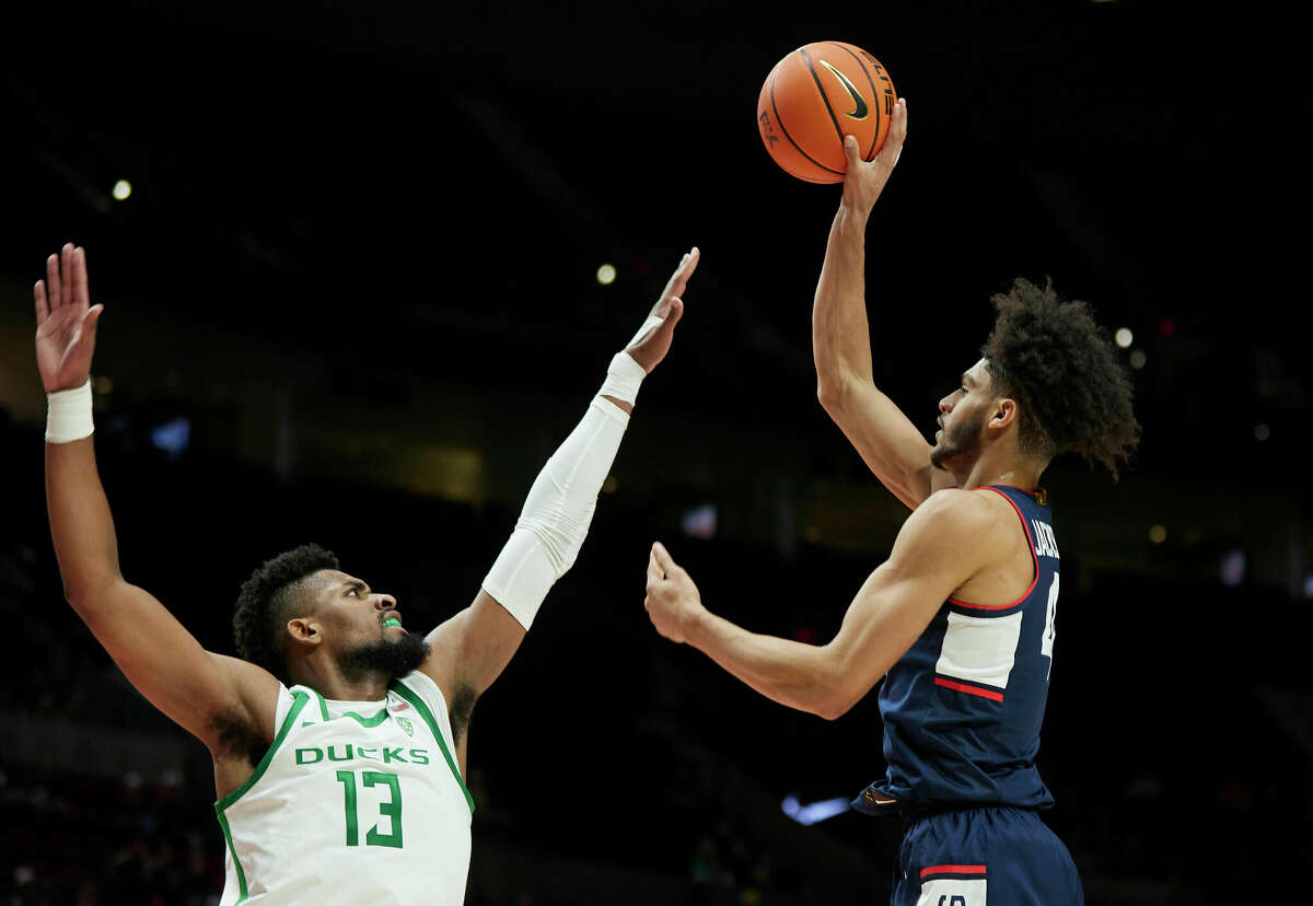 Connecticut guard Nahiem Alleyne, right, shoots over Oregon forward Quincy Guerrier during the first half of an NCAA college basketball game in the Phil Knight Invitational tournament in Portland, Ore., Thursday, Nov. 24, 2022. (AP Photo/Craig Mitchelldyer)