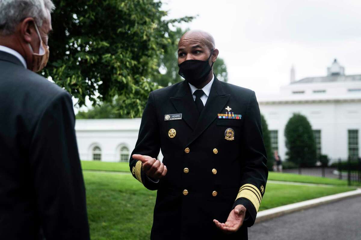 Surgeon General Jerome Adams speaks to Rep. Brad Wenstrup (R-Ohio) before an interview in 2020 at the White House.