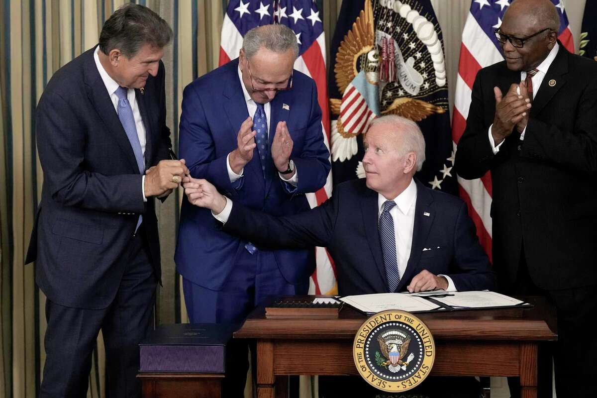 Senate Majority Leader Chuck Schumer, D-N.Y., second from left, stands behind President Joe Biden on Aug. 16 as he signs the Inflation Reduction Act, which included a tax on share buybacks. In 2019, Schumer was among those who introduced legislation to curb that practice. Also picutred are Sen. Joe Manchin, D-W.Va., left; and House Majority Whip James Clyburn, D-S.C.