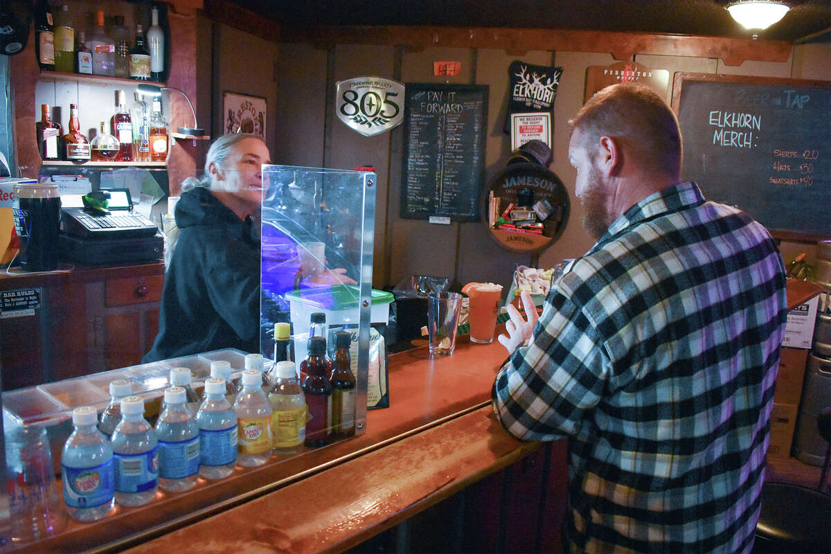 A customer settles up at the Elkhorn Bar in San Miguel, Calif. 