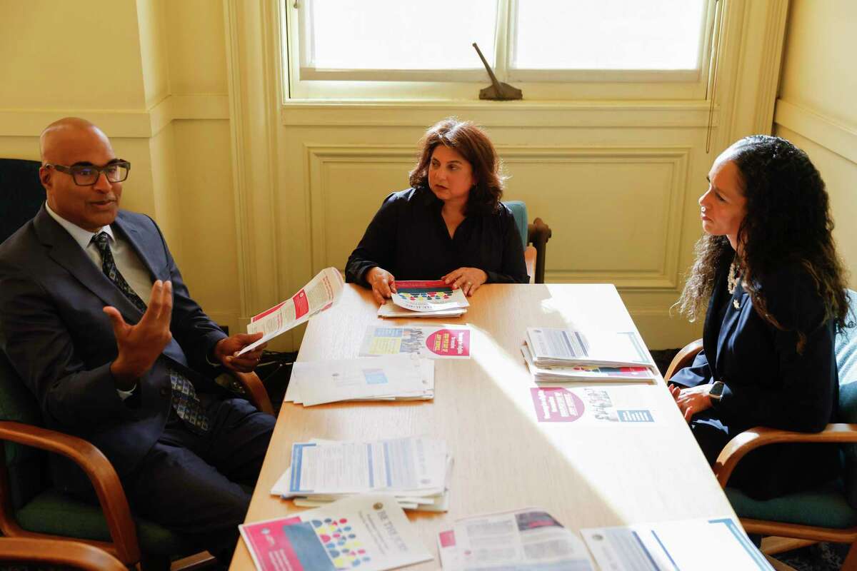 San Francisco Public Defender Mano Raju (left), Chief Assistant City Treasurer Tajel Shah and District Attorney Brooke Jenkins review applications for the Be the Jury pilot program, which pays low-income jurors $100 per day.