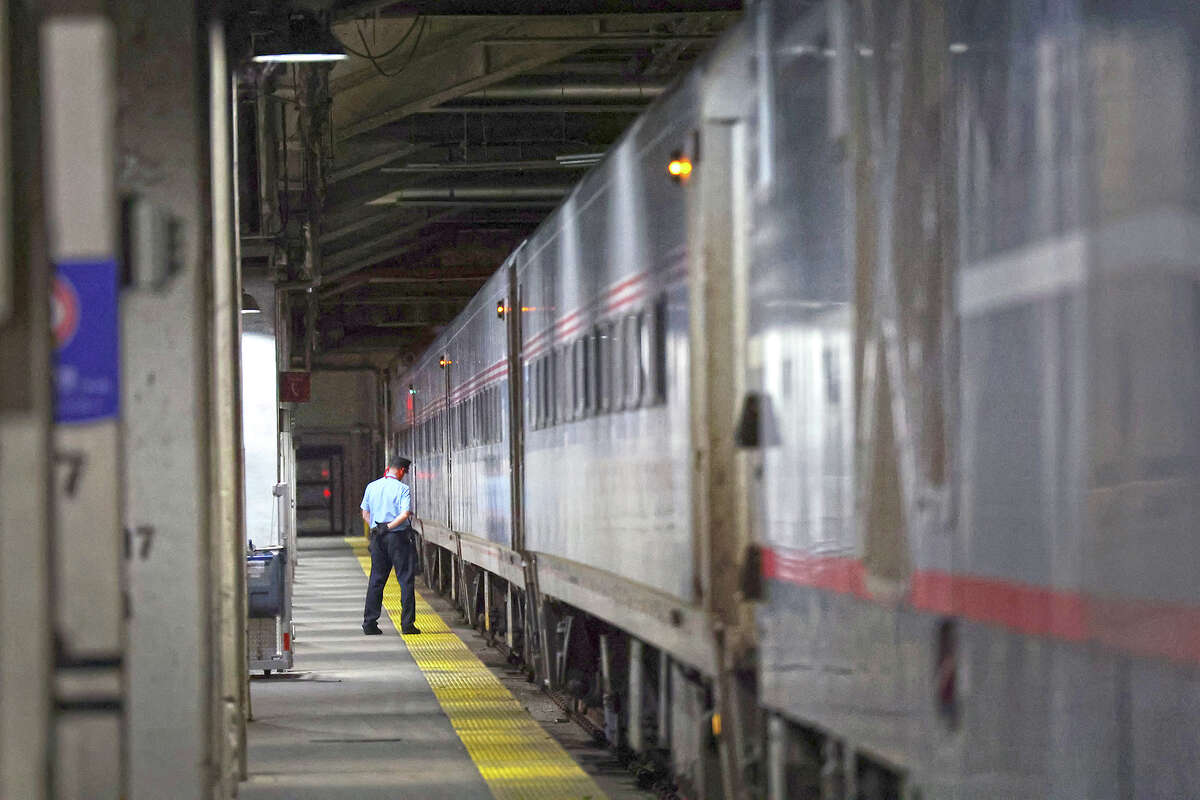 Amtrak conductor Kurt Pipenhagen helps to board passengers for a train to Milwaukee.