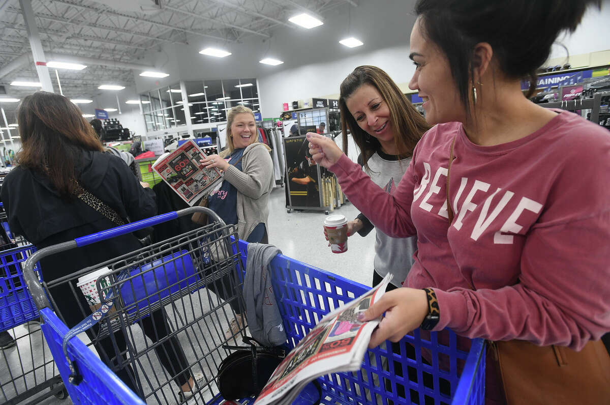 From left, Amber Lakey, Lesa Langham and Brittany Parks joke as they check out the sales before shopping at Academy Sports + Outdoors on Black Friday. Photo made Friday, November 25, 2022 Kim Brent/Beaumont Enterprise