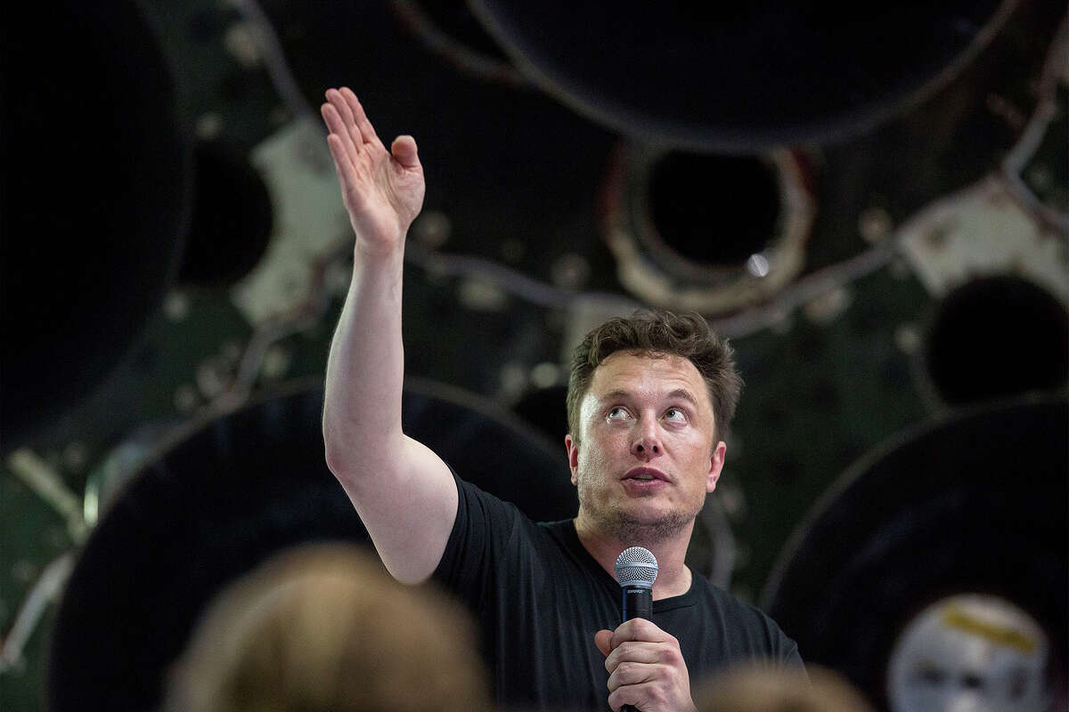 Elon Musk speaks near a Falcon 9 rocket at the SpaceX headquarters and rocket factory on September 17, 2018 in Hawthorne, California.