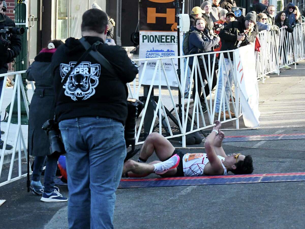 Xavier Salvador of Washington, D.C., right, and fellow Troy Turkey Trot 10K competitor Jack Huber of Delmar lay by the finish line after Salvador squeezed Huber to the rail causing a collision as they battled for fourth place on Thursday morning, Nov. 24, 2022, in Troy, N.Y. Salvador was disqualified for unsportsmanlike conduct.
