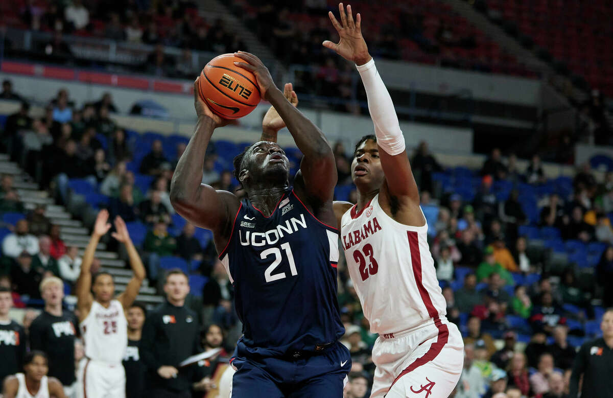 Connecticut forward Adama Sanogo, left, looks to shoot over Alabama forward Nick Pringle during the first half of an NCAA college basketball game in the Phil Knight Invitational tournament in Portland, Ore., Friday, Nov. 25, 2022. (AP Photo/Craig Mitchelldyer)