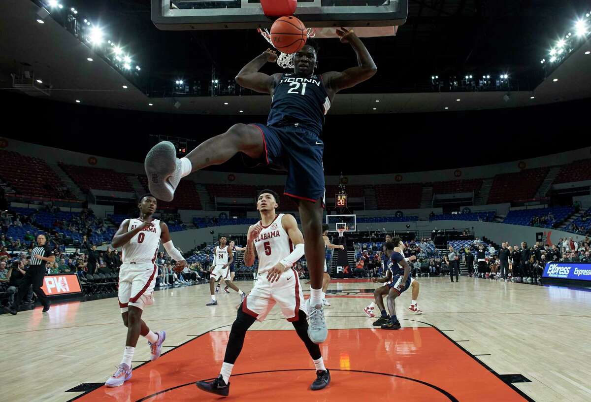 Connecticut forward Adama Sanogo (21) dunks in front of Alabama guard Jaden Bradley (0) and guard Jahvon Quinerly (5) during the second half of an NCAA college basketball game in the Phil Knight Invitational tournament in Portland, Ore., Friday, Nov. 25, 2022.