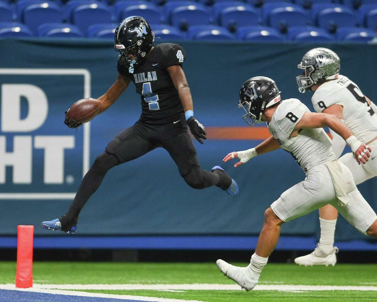 Harlan’s Payton Matthews (4) jumps to a touchdown as Vandegrift defenders Alex Foster (8) and Conner Freeman (9) chase him during Class 6A-II Regional Semifinal football action in the Alamodome on Friday, Nov. 25 2022. Vandegrift won, 49-21.