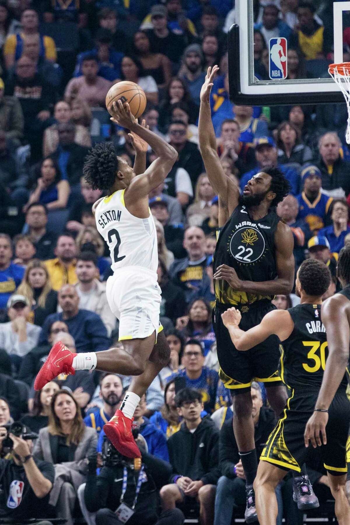 Utah Jazz guard Collin Sexton (2) shoots over Golden State Warriors forward Andrew Wiggins (22) during the first half of an NBA basketball game in San Francisco, Friday, Nov. 25, 2022. (AP Photo/John Hefti)