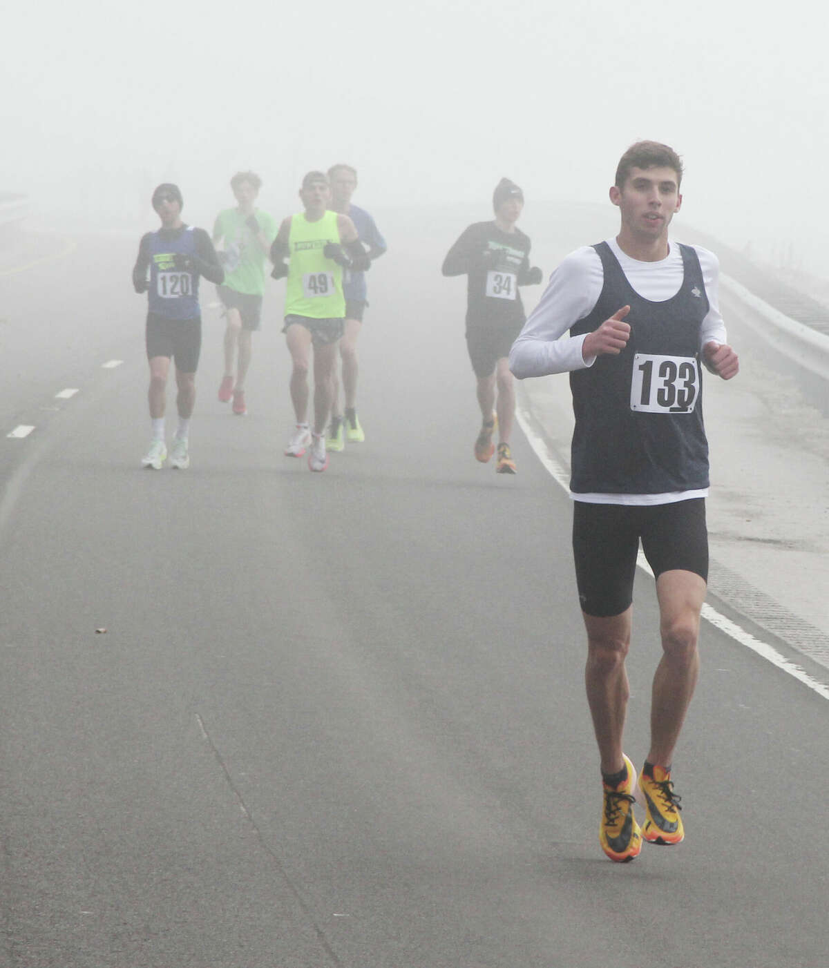 Evin Rathgeb (133), who placed 4th, comes out of the fog during the annual Great River Road Run, sponsored by the Alton Road Runner’s Club. About 360 people participated in the 10-mile and 5K runs, which were held under heavy fog coming off the river.