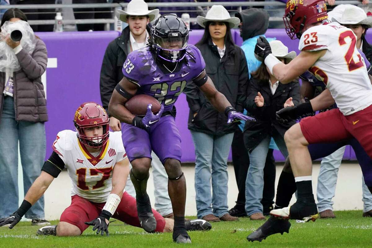 TCU running back Kendre Miller beats Iowa State defenders Beau Freyler (17) and Will McLaughlin on his way to score a touchdown during the first half of an NCAA college football game in Fort Worth, Texas, Saturday, Nov. 26, 2022.