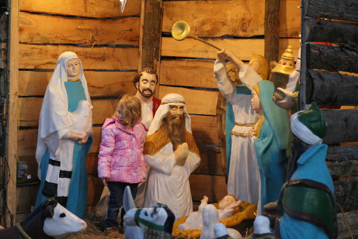 A live nativity scene at Bay Shore Camp and Familiy Ministries in Sebewaing on Saturday, Dec. 3, will be an outside drive-thru performance with several real-life actors and animals in the scene. Above, a child stands at a traditional nativity scene in Bad Axe on Nov. 26.