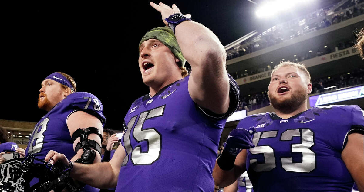 TCU quarterback Max Duggan (15) reacts on the sidelines with teammates guards John Lanz (53) and Wes Harris during the second half of an NCAA college football game against Iowa State in Fort Worth, Texas, Saturday, Nov. 26, 2022. TCU won 62-14. (AP Photo/LM Otero)