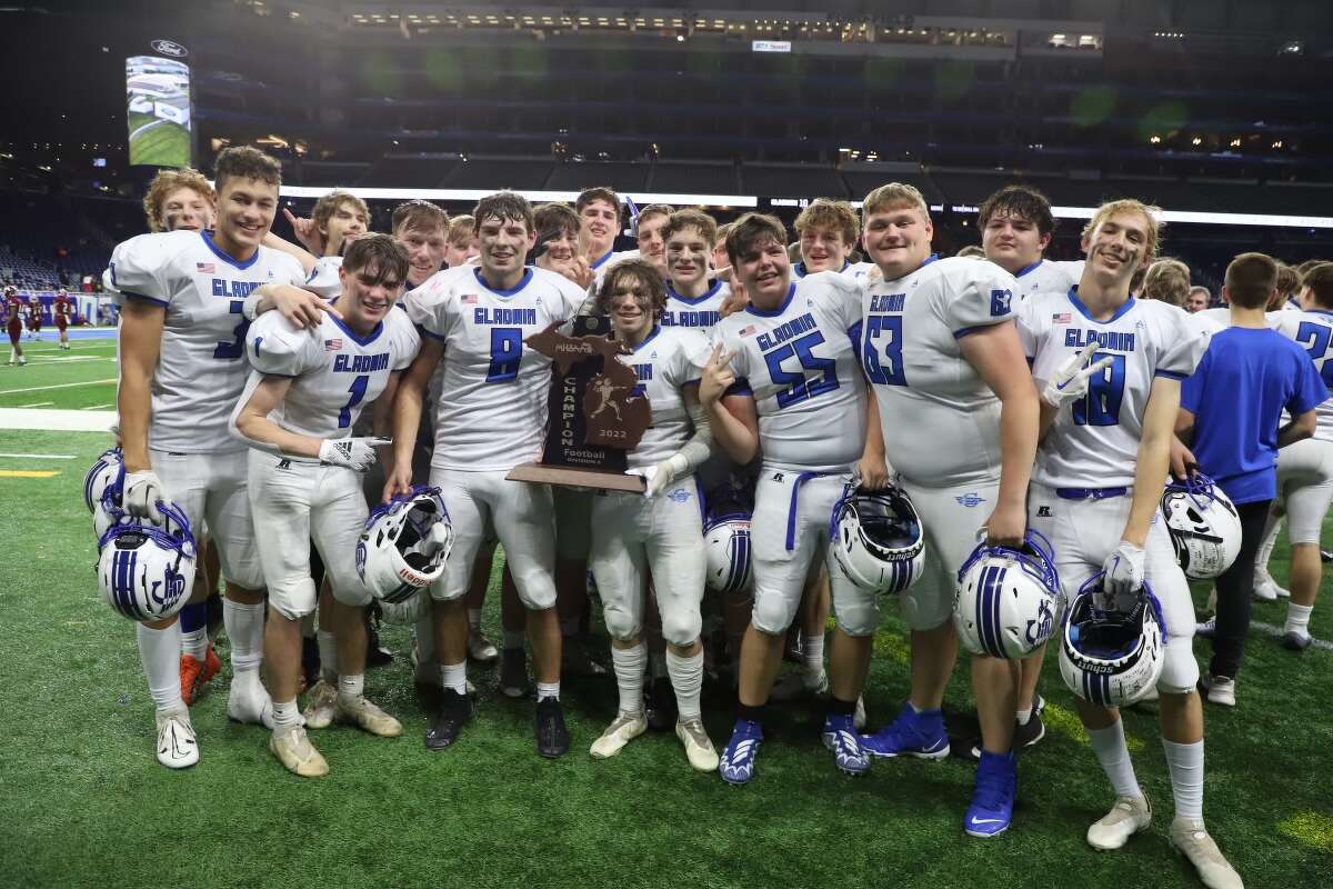 Gladwin's football team poses with the trophy after Saturday's Division 5 state championship game against Frankenmuth at Ford Field in Detroit, Nov. 26, 2022.