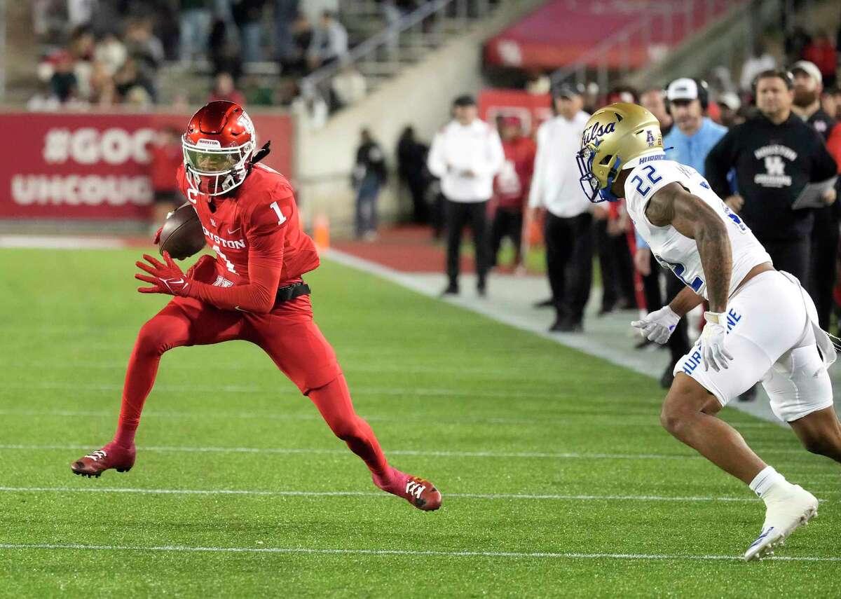 Houston Cougars wide receiver Nathaniel Dell (1) jumps away from Tulsa Golden Hurricane safety LJ Wallace (22) during the first half of an NCAA football game at TDECU Stadium on Saturday, Nov. 26, 2022 in Houston .