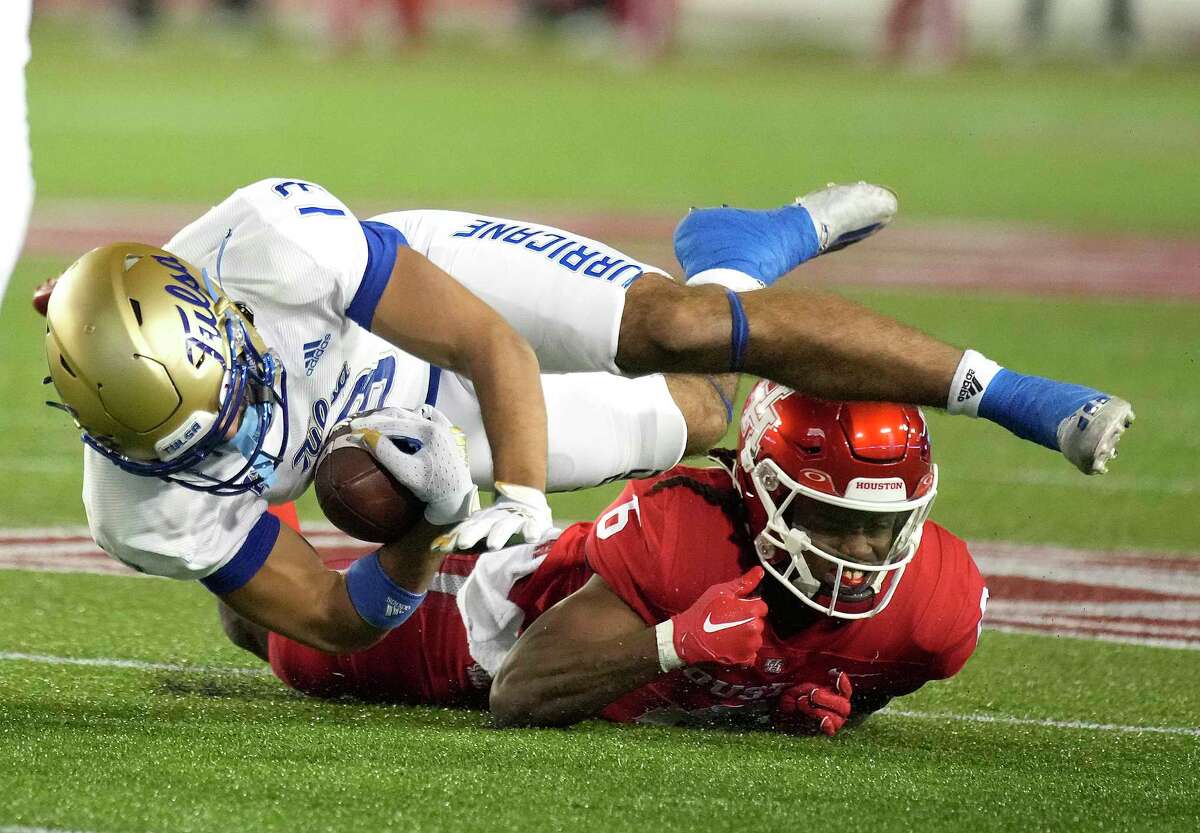 Tulsa Golden Hurricane wide receiver Malachai Jones (13) is stopped by Houston Cougars defensive back Jayce Rogers (6) during the first half of an NCAA football game at TDECU Stadium on Saturday, Nov. 26, 2022 in Houston .