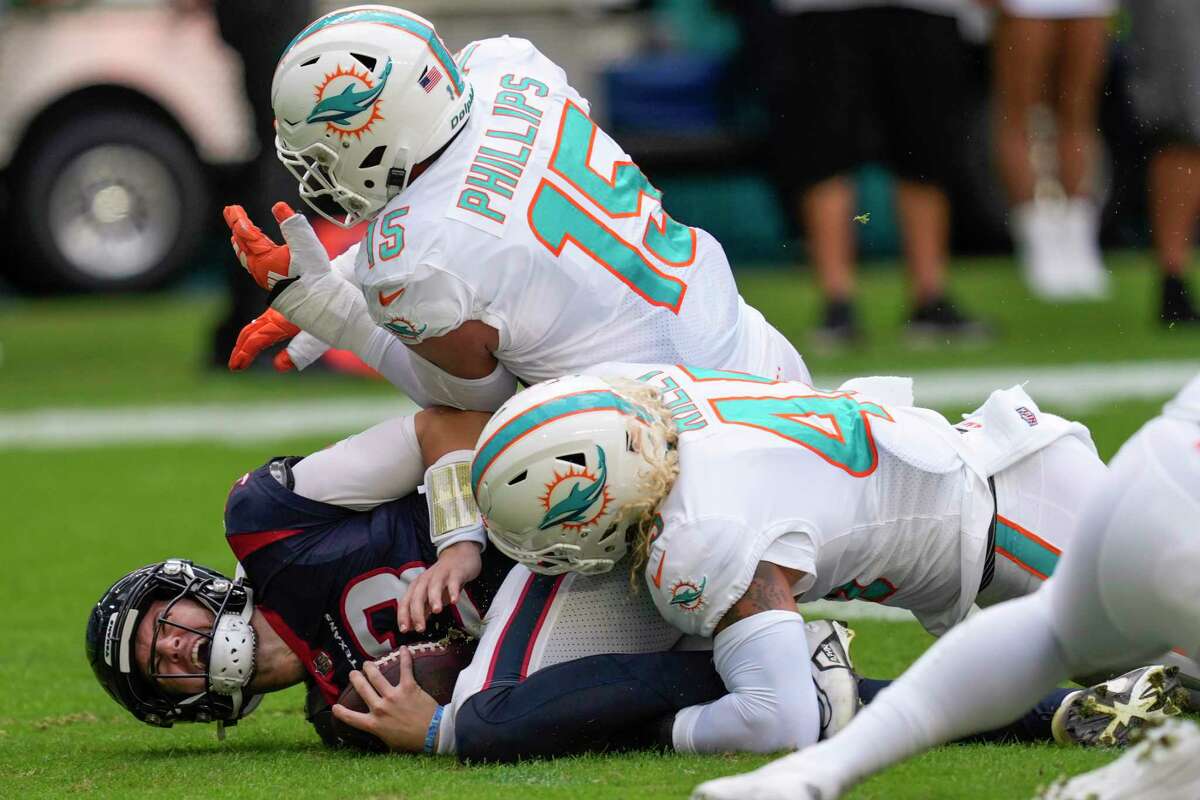 Houston Texans quarterback Kyle Allen (3) is sacked by Miami Dolphins linebackers Duke Riley (45) and Jaelan Phillips (15) during the first half of an NFL football game Sunday, Nov. 27, 2022, in Miami Gardens, Fla.
