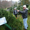 John Denne helps Old Greenwich's Katja Pita pick out a tree at the 56th annual Christmas tree and wreath sale at First Congregational Church in Old Greenwich, Conn. Sunday, Nov. 27, 2022. The sale featured 515 New Hampshire fraser and balsam fir trees and more than 300 balsam and mixed greens wreaths. All proceeds will go to local charities Abilis, Barbara's House, Building One Community, Mothers for Others, Pacific House, and the First Church Fund to benefit New Covenant Center Soup Kitchen.