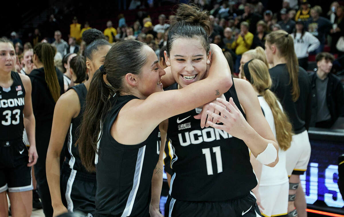UConn forward Lou Lopez-Senechal (11) and guard Nika Muhl celebrate winning the championship over Iowa 86-79 in an NCAA college basketball game in the Phil Knight Legacy tournament in Portland, Ore., Sunday, Nov. 27, 2022. (AP Photo/Craig Mitchelldyer)