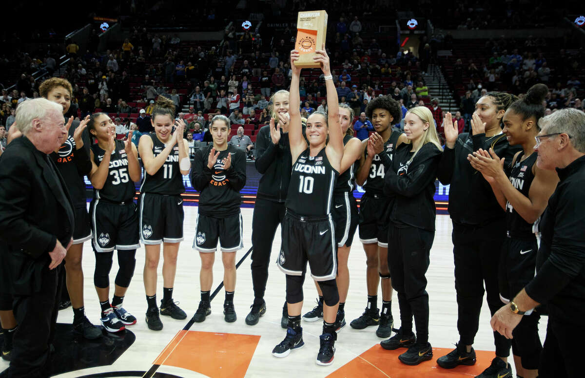 UConn guard Nika Muhl holds up the championship trophy after defeating Iowa 86-79 in an NCAA college basketball game in the Phil Knight Legacy tournament in Portland, Ore., Sunday, Nov. 27, 2022. (AP Photo/Craig Mitchelldyer)