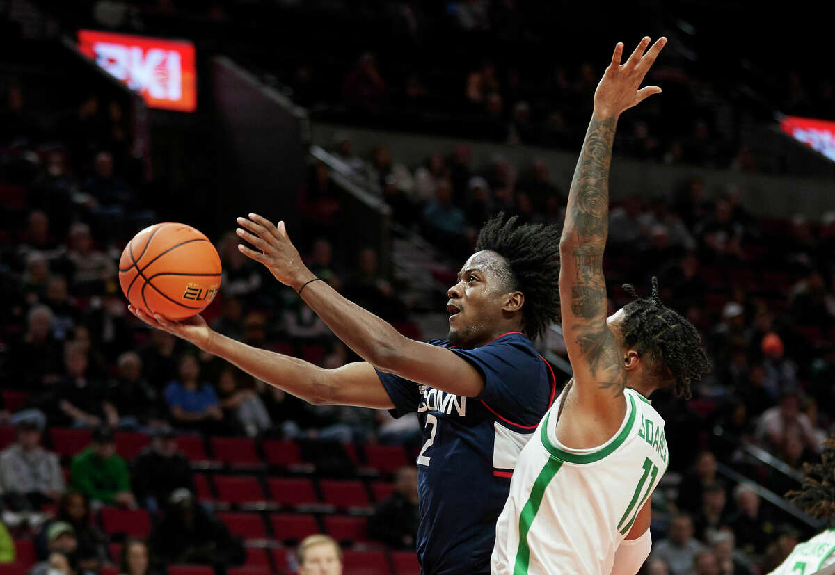 Connecticut guard Tristen Newton, left, shoots in front of Oregon guard Rivaldo Soares during the first half of an NCAA college basketball game in the Phil Knight Invitational tournament in Portland, Ore., Thursday, Nov. 24, 2022. (AP Photo/Craig Mitchelldyer)