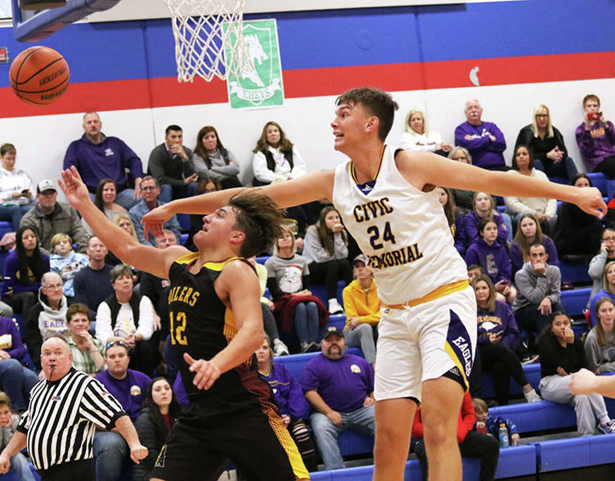 CM's Sam Buckley (right) blocks a shot by EA-WR's Tyler Robinson in the seventh-place game of the Hoopsgiving Classic on Saturday in Roxana.