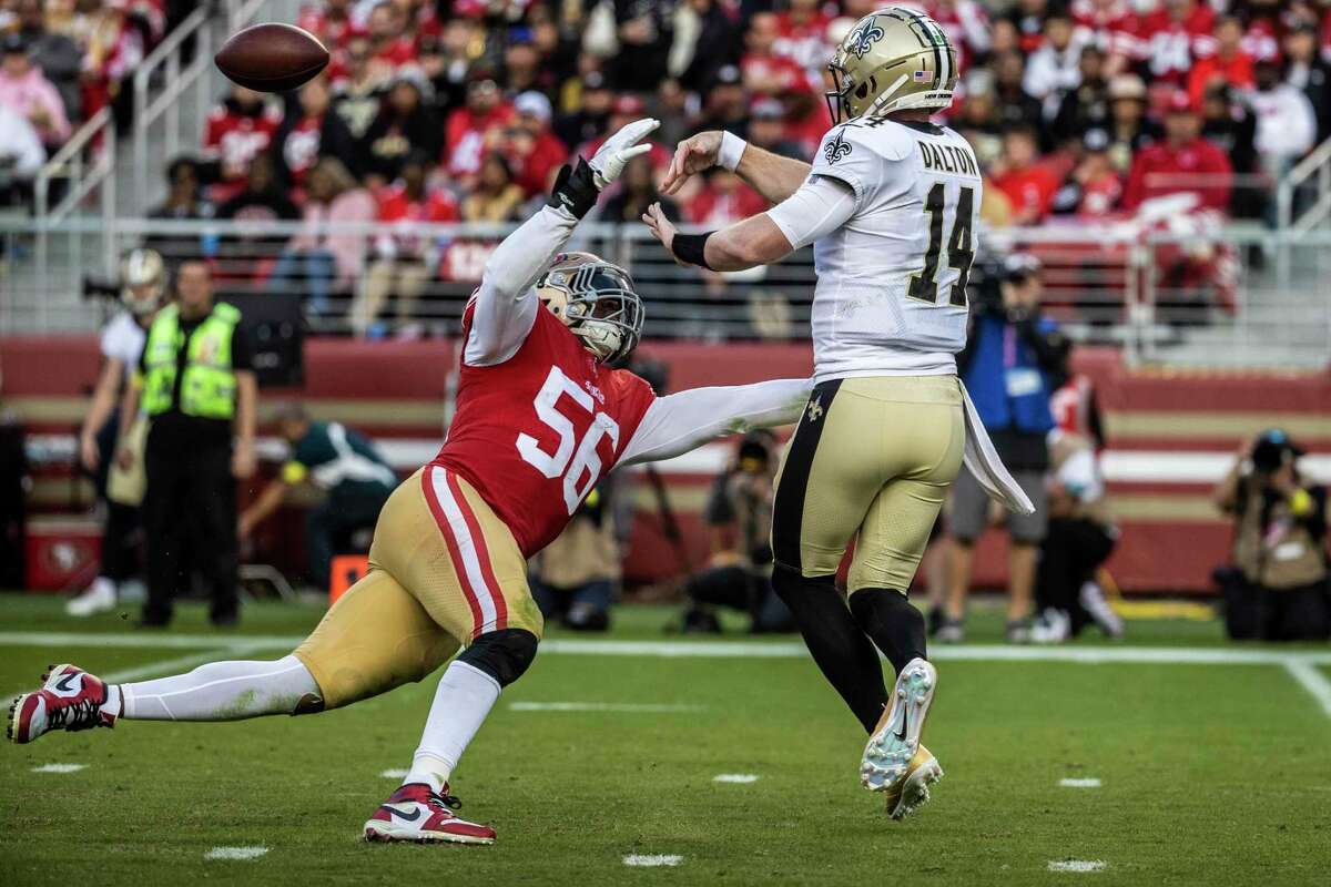 New Orleans Saints quarterback Andy Dalton (14) tosses the ball as San Francisco 49ers defensive end Samson Ebukam (56) pressures during the second half of a NFL football game in Santa Clara, Calif., Sunday, Nov. 27, 2022. The 49ers defeated the Saints 13-0.