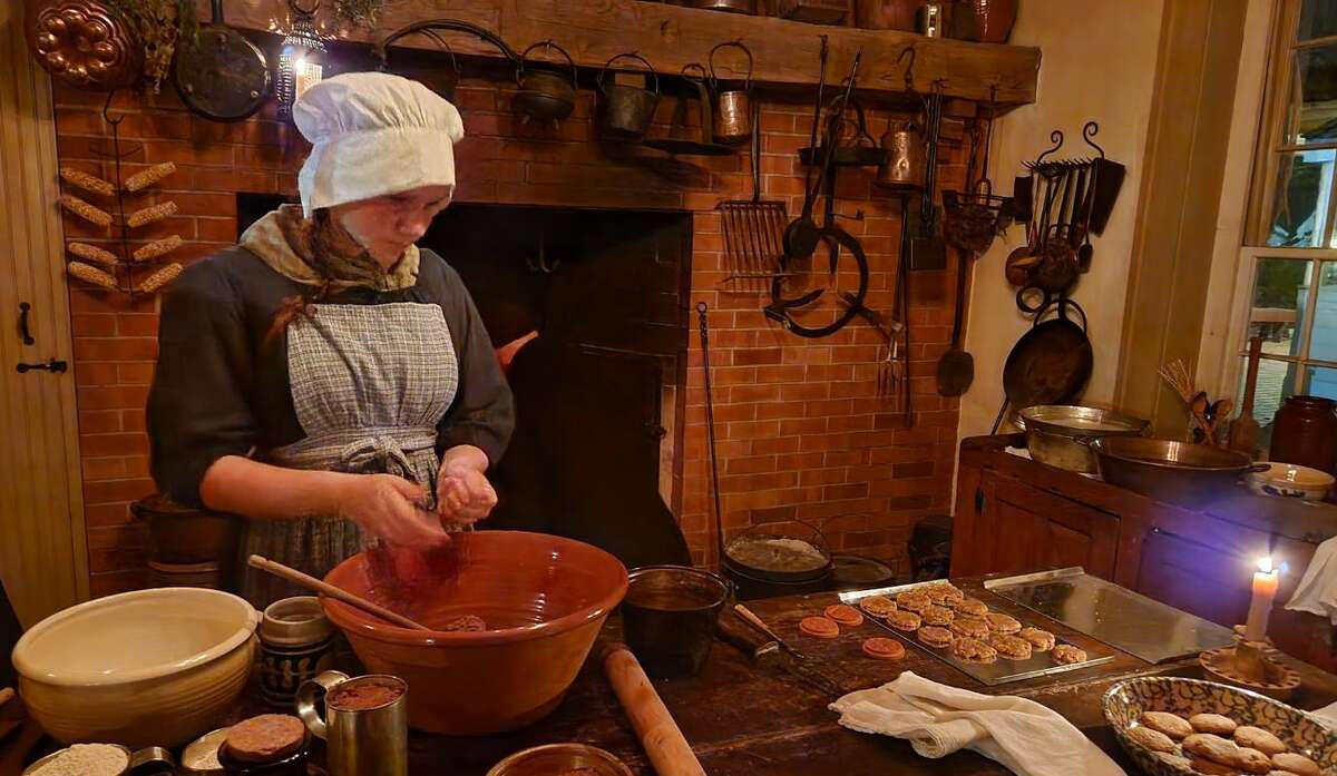 A costumed historic interpreter prepares a meal Saturday in the 1820 Col. Benjamin Stephenson House in Edwardsville as part of the annual Christmas Candlelight Tour. For more photos, visit the home's Facebook page.