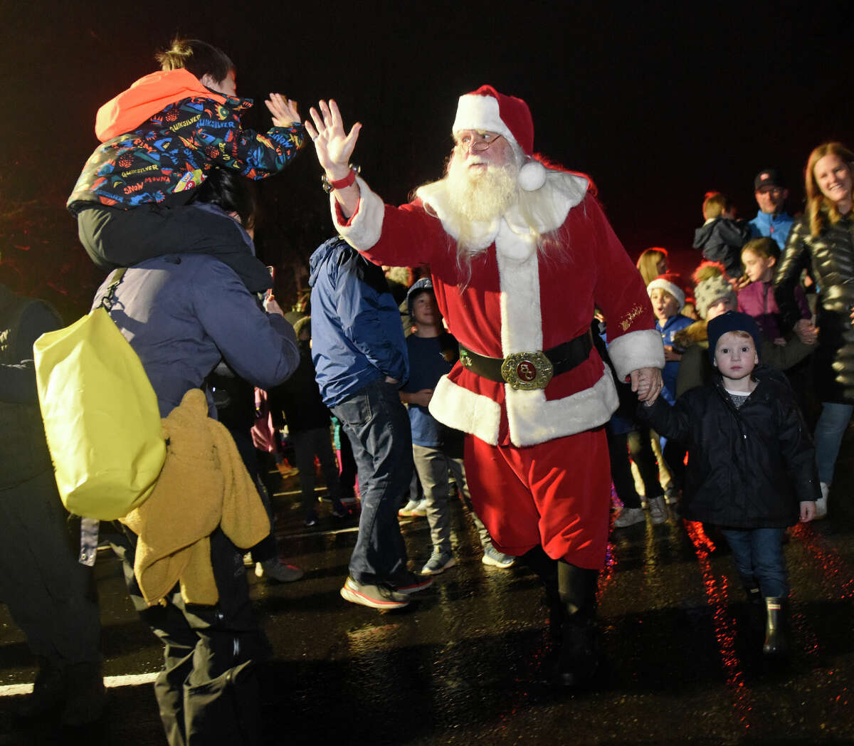 Santa Claus arrives to the annual Christmas tree lighting ceremony outside Darien Sport Shop in Darien, Conn. Sunday, Nov. 27, 2022. Santa arrived in the rain Sunday to help light the Christmas tree and pose for photos with children afterwards.