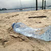 An empty plastic water bottle lies on a Long Island Sound beach. In an effort to reduce litter, Connecticut lawmakers approved an expansion of the state's nickel-return program to include teas, juices and seltzers. 