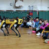 The Boston Dynamics robot dog, Spot, performs a demonstration for students at Julian Curtiss School in Greenwich, Conn. Monday, Nov. 28, 2022. Artist Agnieszka Pilat is acclaimed teaching the robot dog, Spot, to paint self portraits and still lifes.