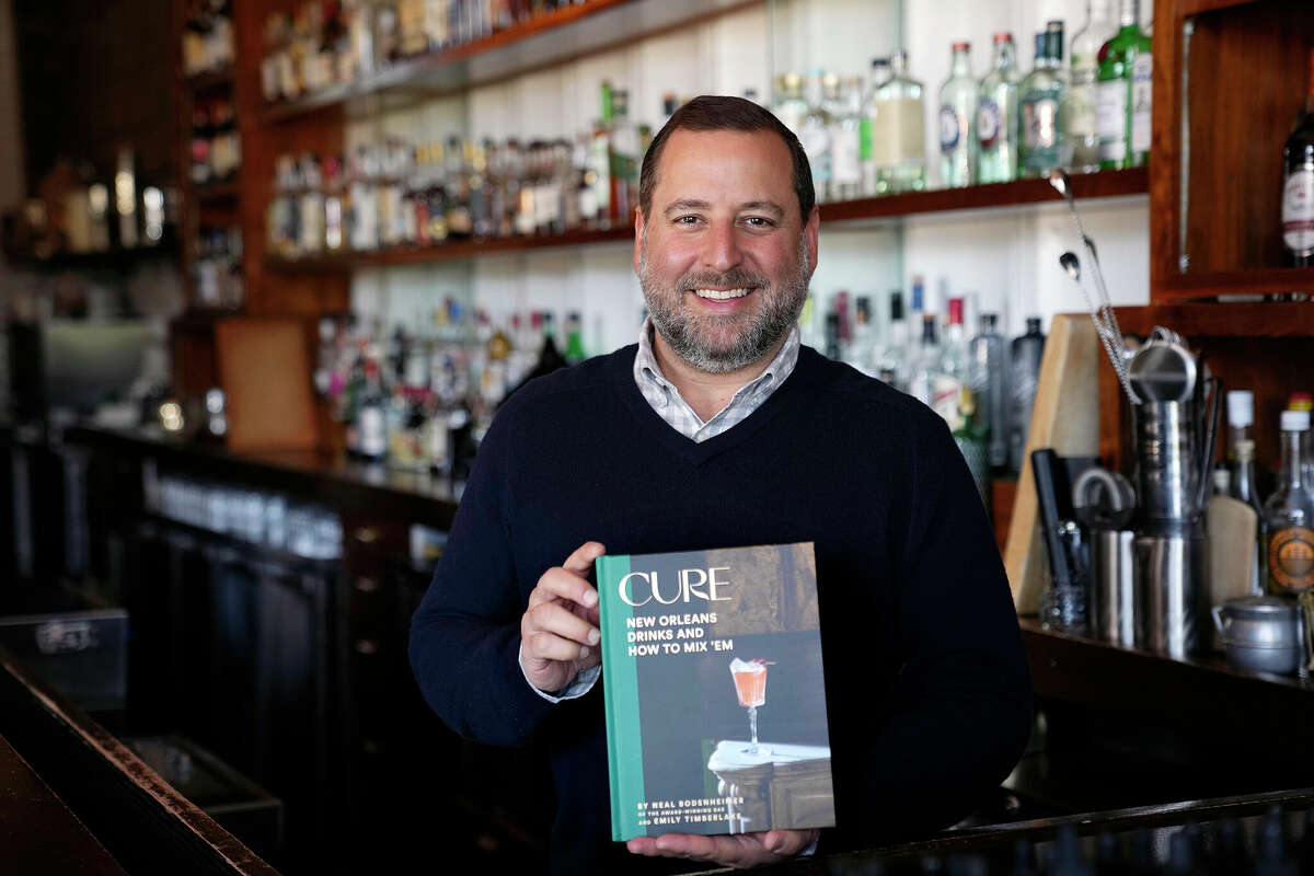 Neal Bodenheimer, owner and founder of Cure, holds a copy of his new book, "Cure: New Orleans Drinks and How to Mix 'Em" at his craft cocktail bar in New Orleans.