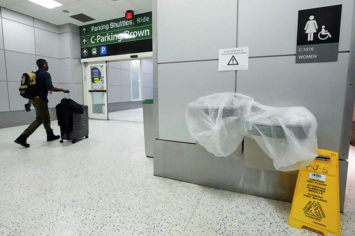 Arriving passengers walk past at closed water fountain at George Bush Intercontinental Airport on Monday, Nov. 28, 2022 in Houston, after a boil water notice was issued for the city. The city of Houston issued the boil water notice late Sunday evening after water pressure dropped below the minimum standard during a power outage at the East Water Purification Plant.