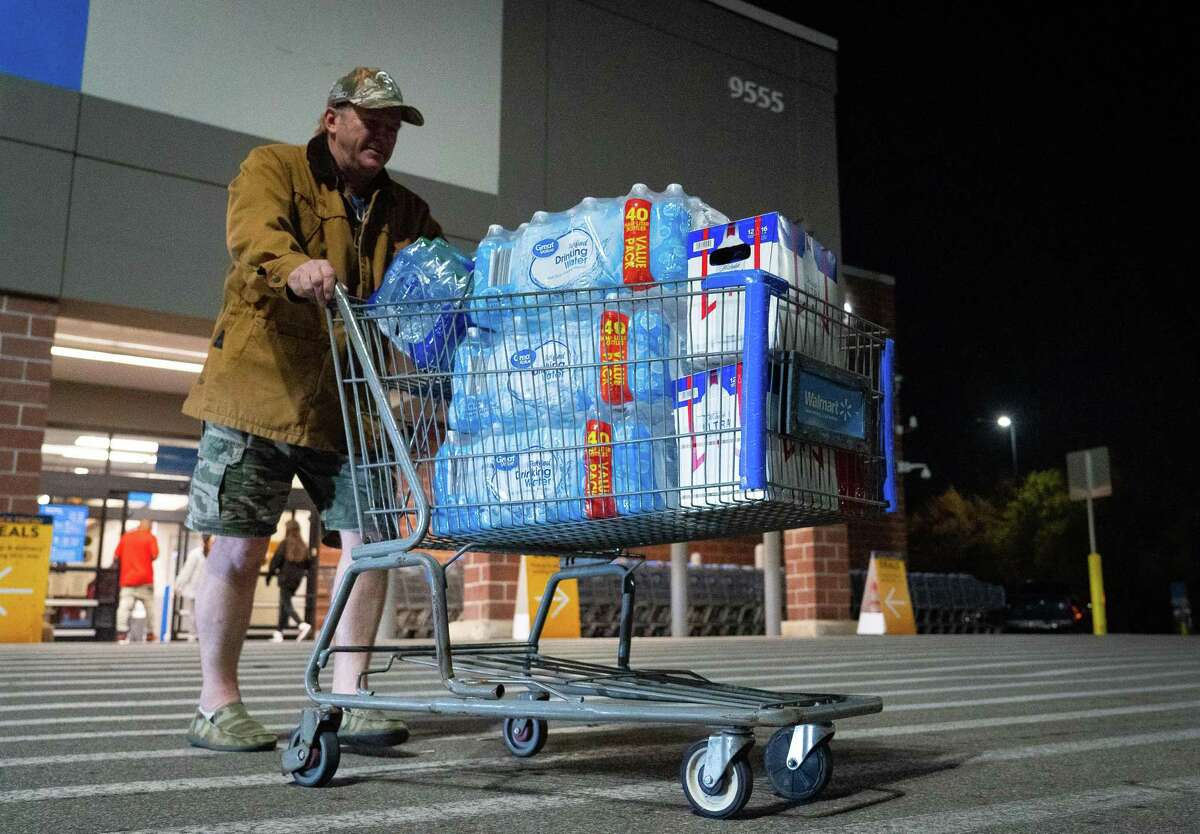 John Beezley, of Bonham, carts out several cases of water after learning that a boil water notice was issued for the entire city of Houston on Sunday, Nov. 27, 2022, at Walmart on S. Post Oak Road in Houston. Beezley just arrived in town with his wife, who is undergoing treatment starting tomorrow at M.D. Anderson Cancer Center, where they are staying in a camping trailer. They turned on the television after settling in and saw that a boil water notice had been issued. Beezley decided to go out immediately fearing that by tomorrow people would be buying up all of the available water.