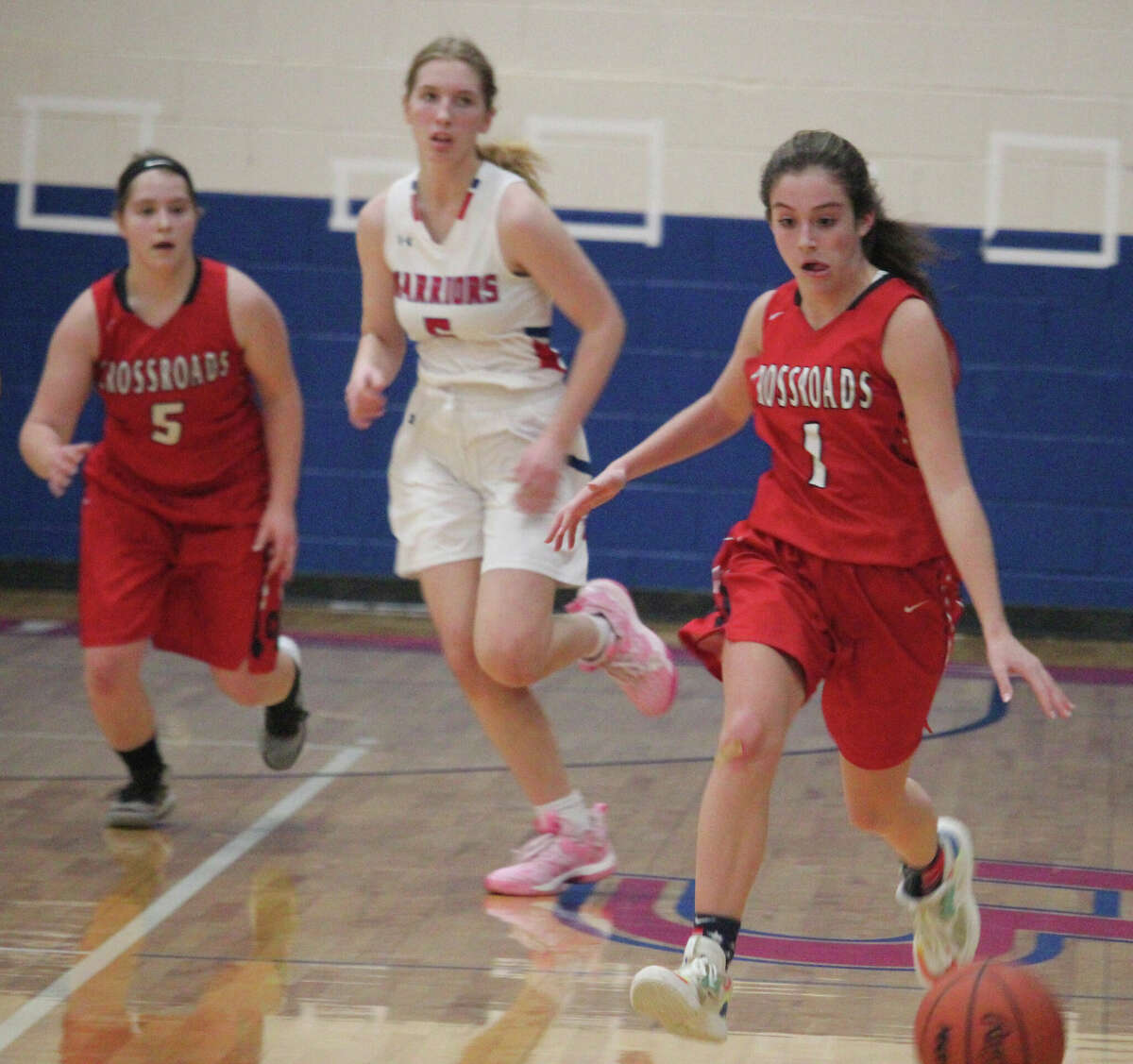 Crossroads Jackie Cole (1) dribbles the ball down the court while teammate Alexis Cole (5) and Chippewa Hills' Ila Swier are in pursuit.