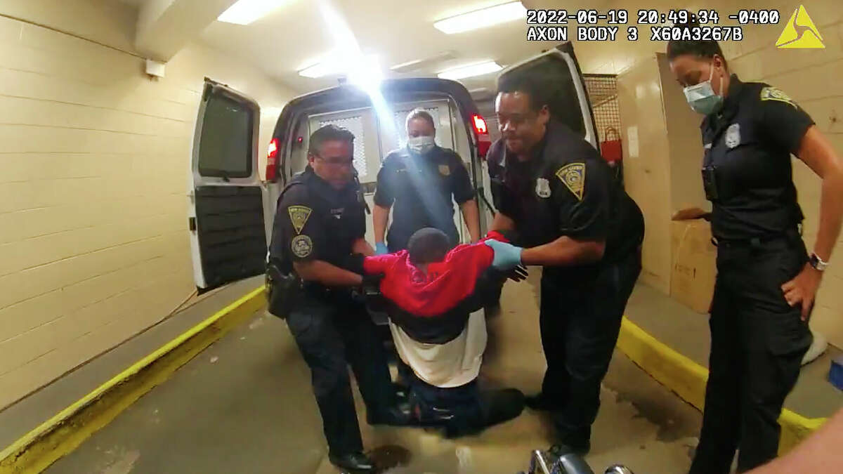 FILE - In this image taken from police body camera video provided by New Haven Police, Richard "Randy" Cox, center, is pulled from the back of a police van and placed in a wheelchair after being detained by New Haven Police on June 19, 2022, in New Haven, Conn. Five Connecticut police officers were charged with misdemeanors Monday, Nov. 28, over their treatment of Cox after he was paralyzed from the chest down in the back of a police van. 