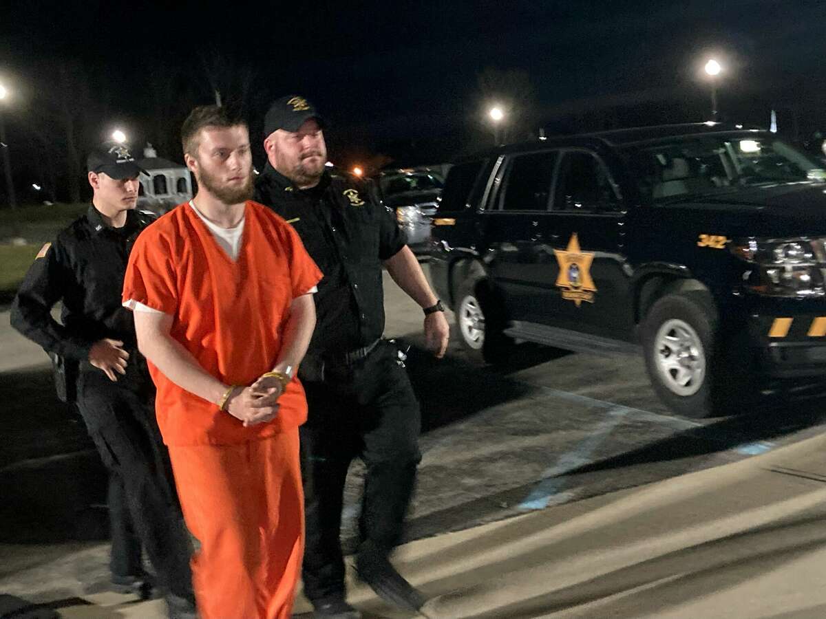 Nicholas Fiebka, 19, is escorted into Princetown Town Court on Monday for a preliminary hearing in the deaths of his mother and her longtime boyfriend. A town justice later ruled there was probable cause Fiebka had committed a crime. 