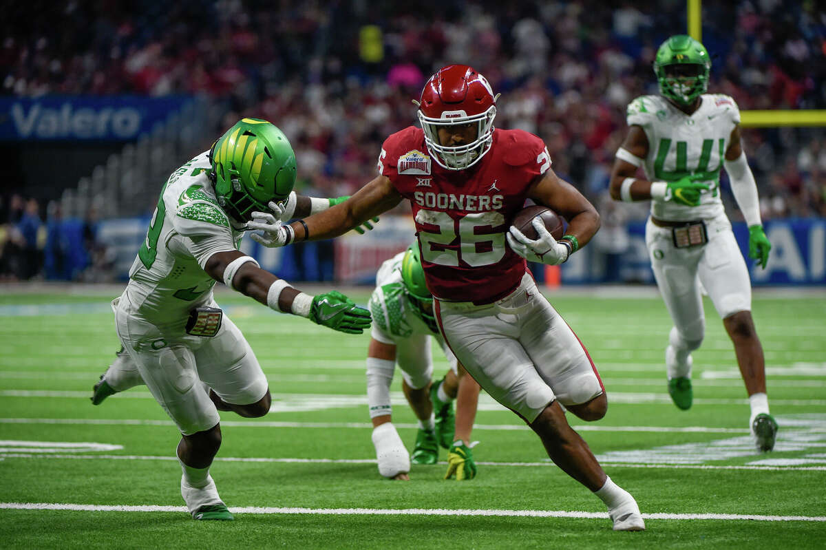 Oklahoma Sooners running back Kennedy Brooks (26) stiff arms Oregon Ducks safety Jeffrey Bassa (33) at the end of a second half during the football game between the Oregon Ducks and Oklahoma Sooners at the Alamodome on December 29, 2021 in San Antonio, TX. 
