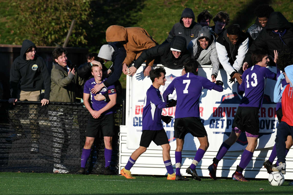 Ellington's Owen Hoffman celebrates with fans after scoring a goal during the Class M boys soccer finals between Ellington and Weston at Trinity Health Stadium on Saturday, Nov. 19, 2022.