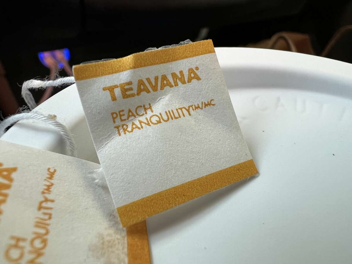 Close-up of statement   for Teavana Peach Tranquility atop a instrumentality  of brewed peach beverage  from a Starbucks cafe.