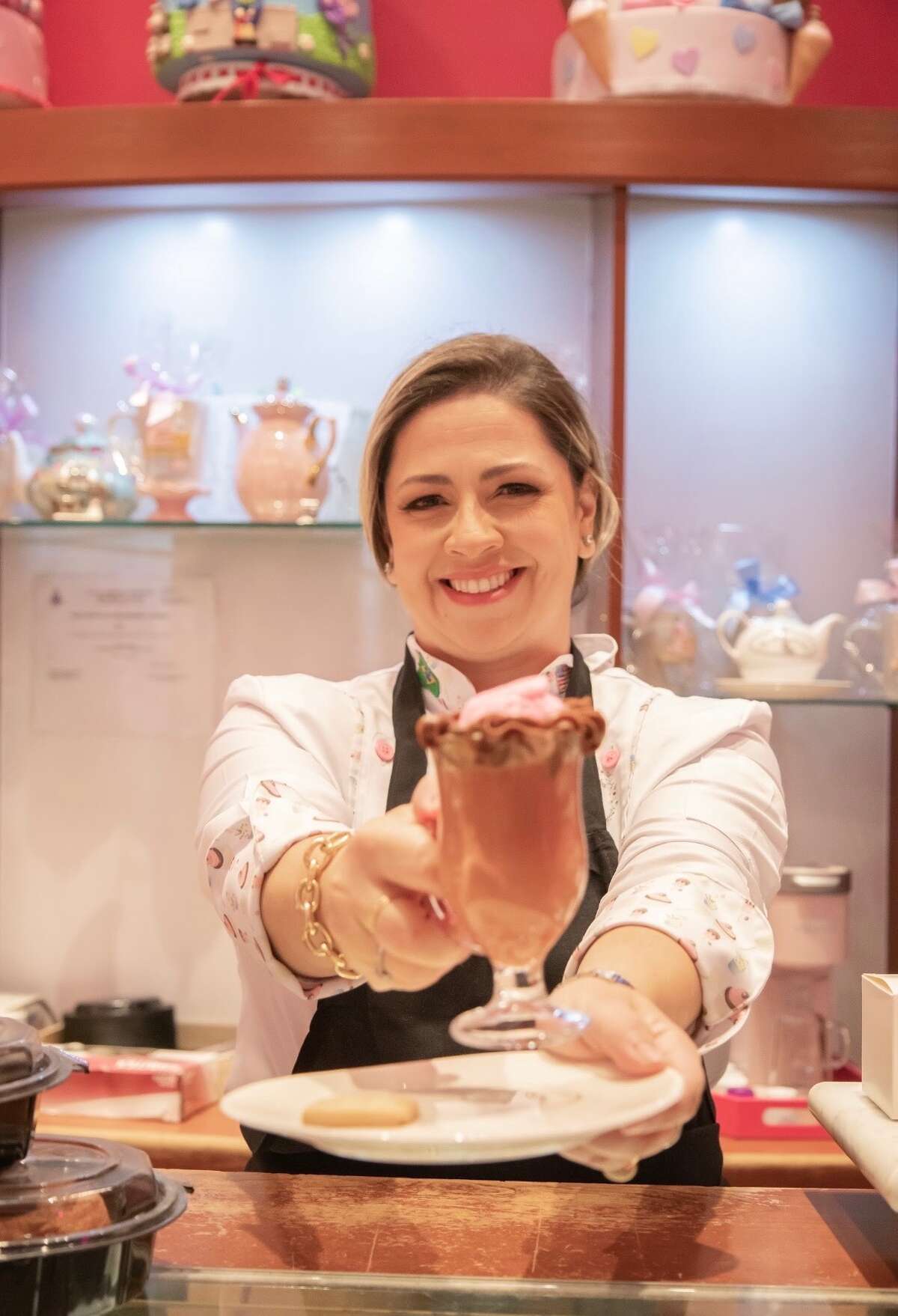 Pink Sweets Cakes owner Fernanda Ferreira holding a pink cappuccino sold in her bakery at the Stamford Town Center.
