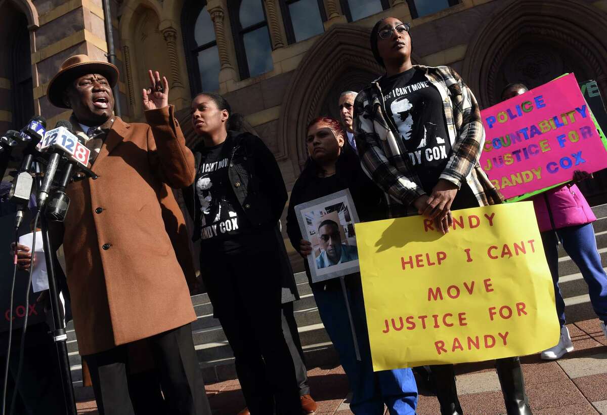 Attorney Benjamin Crump, left, speaks at a news conference in front of City Hall in New Haven on November 29, 2022 following the arrest of five New Haven Police officers in connection with injuries sustained by Richard "Randy" Cox while in police custody alongside Cox's sisters LaToya Boomer, left center, and LaQuavius LeGrant, far right.