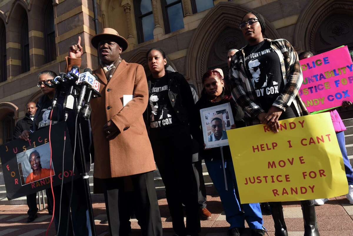 Attorney Benjamin Crump, left, speaks at a news conference in front of City Hall in New Haven on November 29, 2022 following the arrest of five New Haven Police officers in connection with injuries sustained by Richard "Randy" Cox while in police custody alongside Cox's mother, Doreen Coleman, far left, and sisters LaToya Boomer, center, and LaQuavius LeGrant, far right.