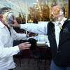 Charlie Andriole, left gets a banana cream pie in the face from Rob DeLucca, who has the remains of a pumpkin pie topped with whipped cream on his face, in front of The Marketplace at Guilford Food Center on November 29, 2022 as part of the Pie Wars Challenge on Giving Tuesday. Funds raised benefit the Community Dining Room.