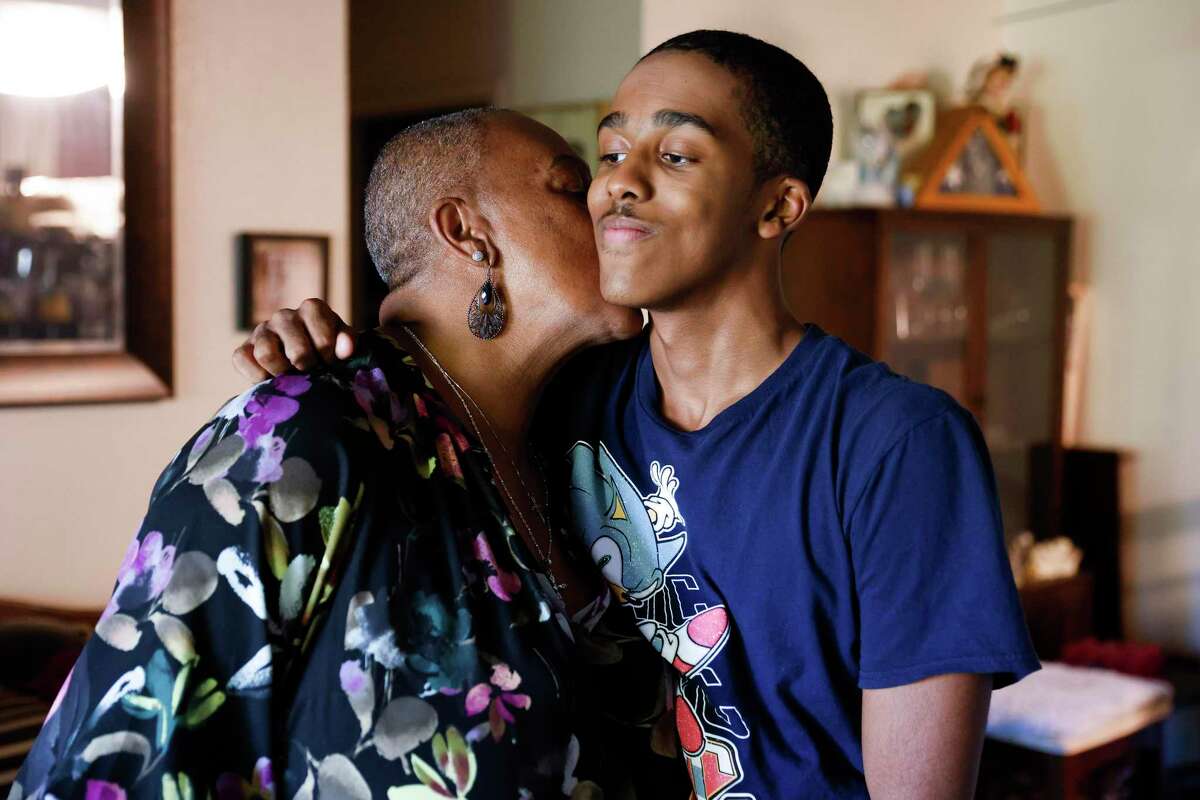 FOR PROJECT USE ONLY. NOT FILE. Teresa Robinson kisses her grandson Hasani Algere-Coleman, 15, at her apartment in Richmond, Calif. Monday, Oct. 24, 2022. Leading up to the pandemic, she was caregiver for her mom, sister, and stepdad, through In Home Support Services. Today, she helps care for her 15-year-old grandson Hasani Algere-Coleman.