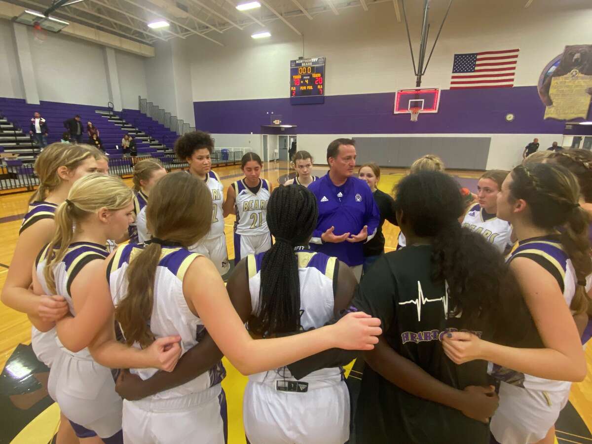 Montgomery girls basketball coach Kelly Savoy, middle, talks to his team after its 78-28 win over Spring Woods on Tuesday at Montgomery High School.